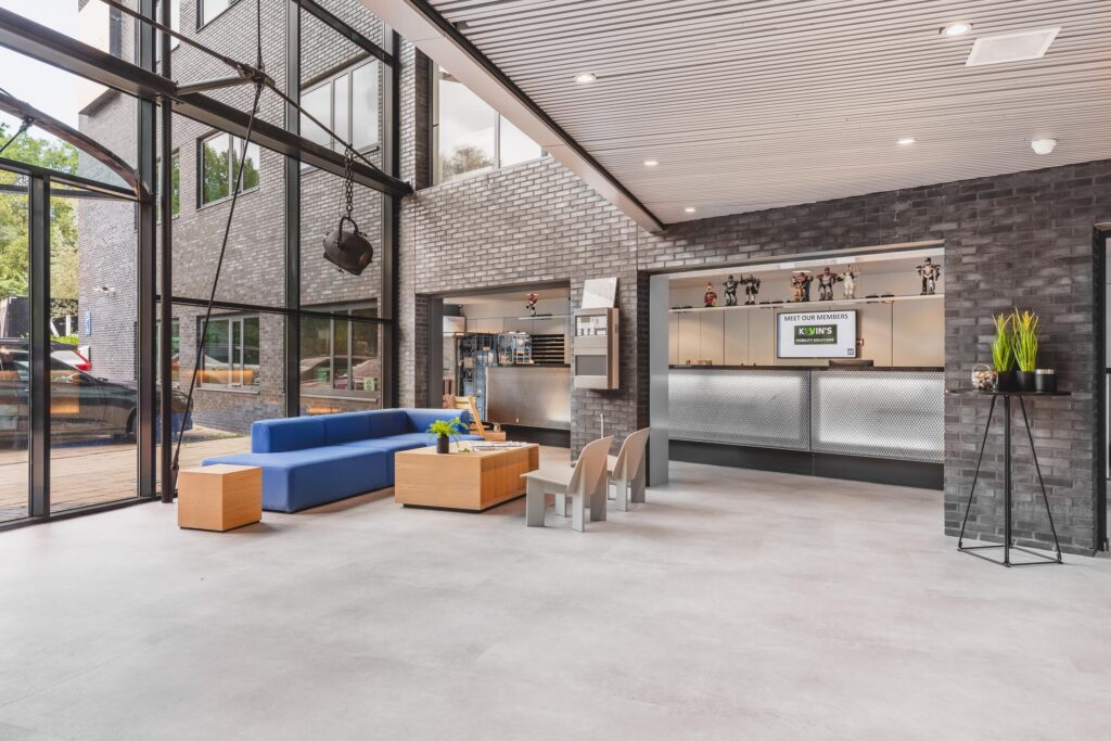 Moderne bedrijfsentree aan de Prof. W.H. Keesomlaan met een zithoek, receptiebalie en grote raampartijen.